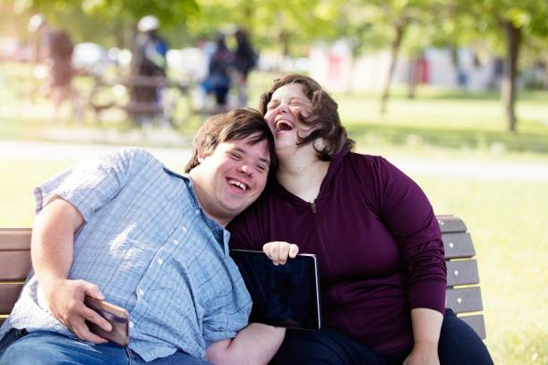 Couple with Down Syndrome working doing selfie with mobile phone
