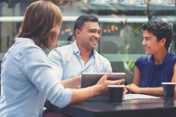 Photo of Happy couple having a business meeting with a financial advisor.