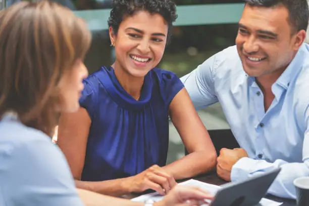 Photo of Happy couple having a business meeting with a financial advisor.