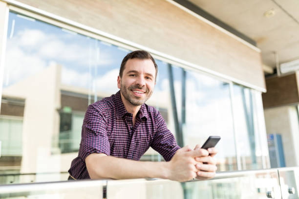 istock Smiling Man Holding Mobile Phone In Shopping Mall 1035804426