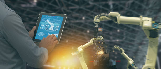 istock iot industry 4.0 concept,industrial engineer using software (augmented, virtual reality) in tablet to monitoring machine in real time.Smart factory use Automation robot arm in automotive manufacturing 1035804466