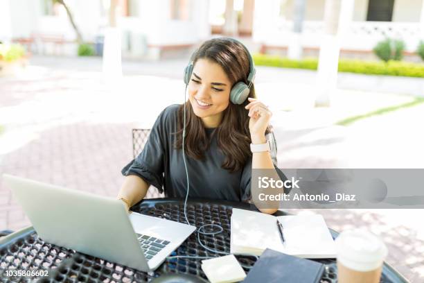 Woman Listening Music While Working Online With Laptop In Garden Stock Photo - Download Image Now