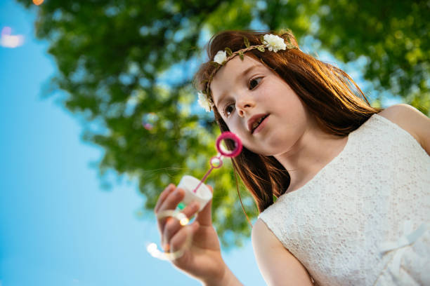 istock Beautiful little girl blowing bubbles 1035806652