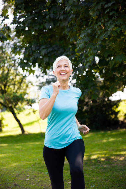 istock Senior woman jogging through park 1035809400