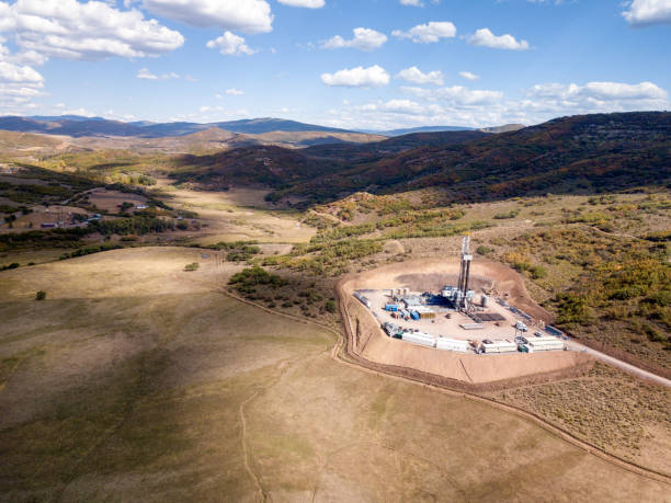 Aerial View of a Fracking Drilling Rig in the Autumn Mountains of Colorado Heroic scene of a fracking drill rig set in the pristine Colorado Rockie Mountains in the Fall fuel and power generation oil industry oil rig industry stock pictures, royalty-free photos & images
