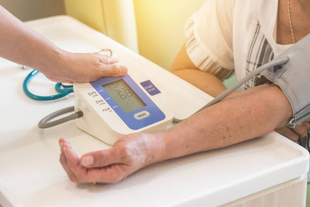 enfermera y ancianos pacientes el control presión arterial mediante la medición de la presión arterial de brazo monitor de equipo médico en sala de examen clínica - human heart physical pressure arterial doctor fotografías e imágenes de stock