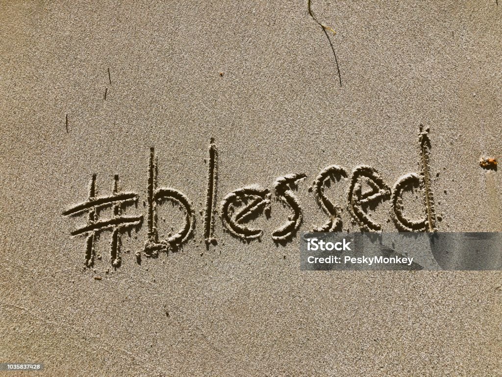 Blessed Message Written in Sand Blessed message with a modern social media hashtag twist written in the sand on the beach Religious Blessing Stock Photo