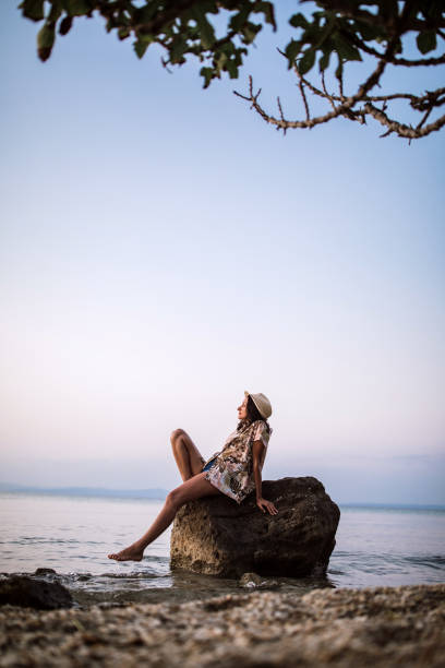 istock Young Woman Looking At Sunset Over Sea 1035844896