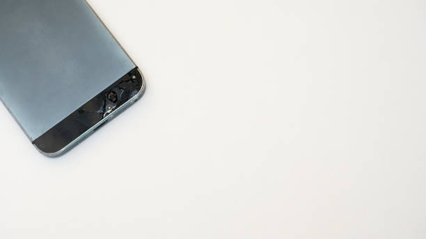 istock close up of black mobile phone with broken  on white background. 1035847954