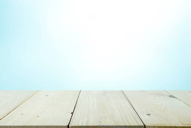 istock Wooden table top with blurred image blue color background for montage and display your products 1035862348