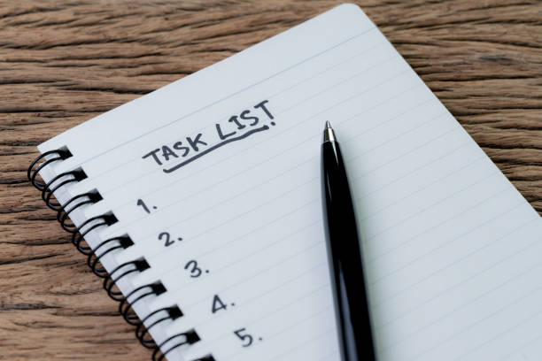 istock Task List, project management concept, pen on white paper notepad with handwritten headline as Task List and numbers listed on wood table, writing business project with tasks prioritize 1035870176
