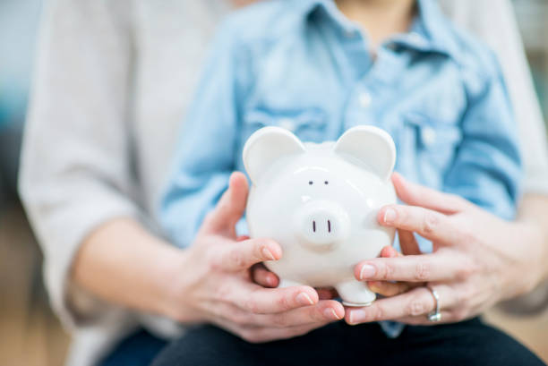 istock Holding A Piggy Bank 1035876116
