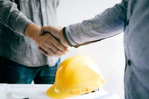 Construction worker greeting a foreman at renovating apartment. stock photo