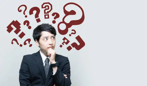 Photo of young man with question marks.