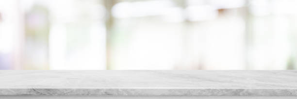 istock Empty white marble Stone table top and blurred bokeh lighting in interior banner background - can used for display or montage your products. 1035883998