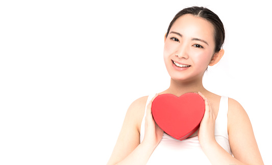 Young woman holding a heart shape.