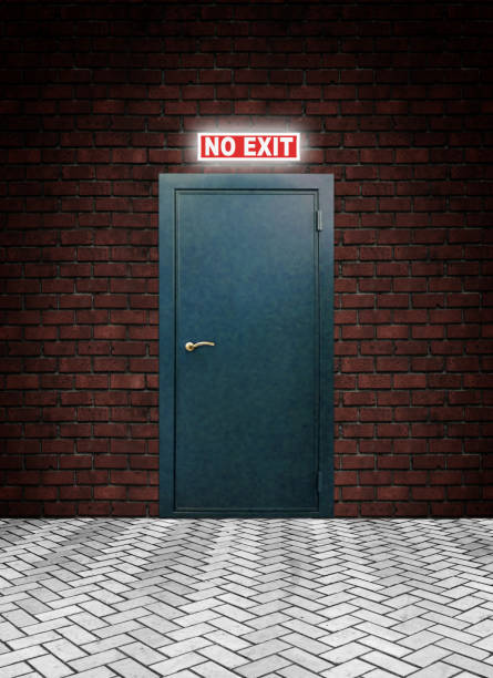 istock Glowing words No Exit above a closed metal door in a brick wall 1035895422