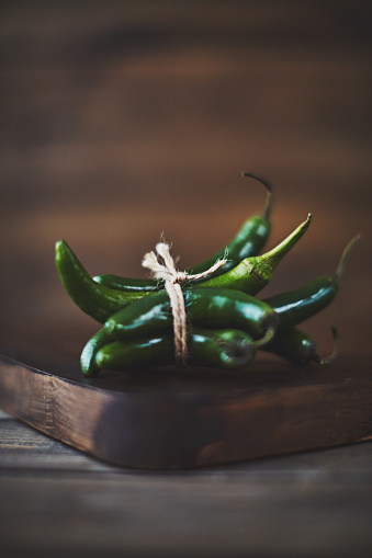 Still life of jalapeno peppers shot in dark moody light