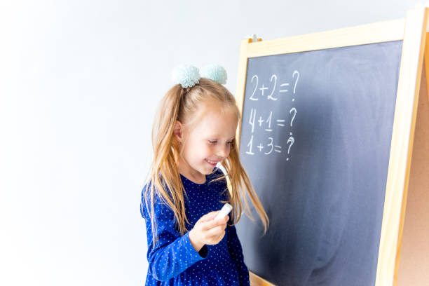 istock Happy cute industrious child is sitting at a desk indoors 1035928024
