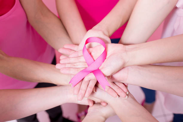 frauen mit brustkrebs-prävention - breast cancer breast cancer awareness ribbon social awareness symbol human hand stock-fotos und bilder