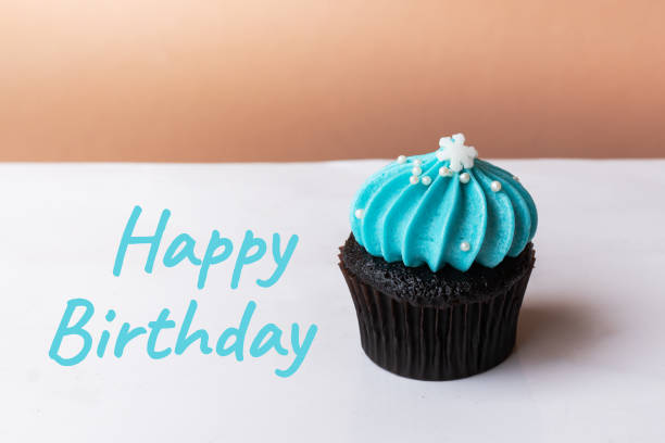 istock Happy Birthday cute cupcake with small white snow blue cream on white background 1035941354