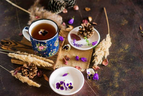 istock Herbal tea: pansies, petals, edible flowers, on a light background 1035941464