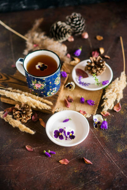 istock Herbal tea: pansies, petals, edible flowers, on a light background 1035941478