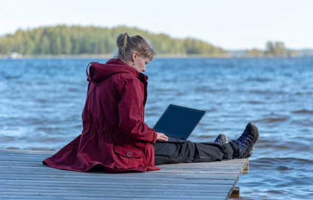 istock Woman using laptop outdoor on the beach 1035944916
