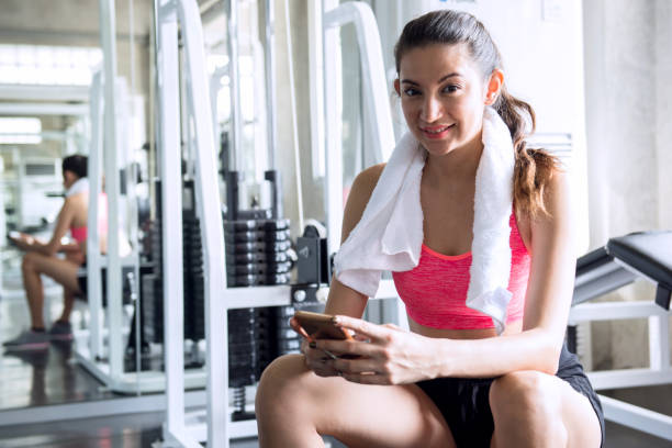 istock A woman resting from exercise and look at mobile phone at gym 1035949726