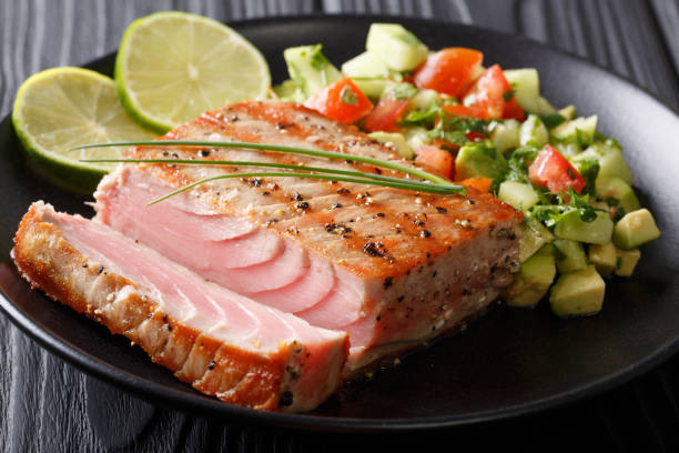 istock Barbecue tuna steak with lime and avocado cucumber salsa closeup. horizontal 1035953222