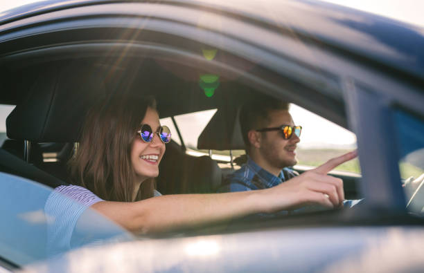 młody mężczyzna prowadzi samochód ze swoją dziewczyną - people behavior smiling mode of transport zdjęcia i obrazy z banku zdjęć