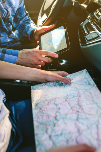 istock Couple comparing paper map and a gps navigator 1035956714