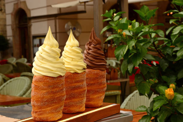 Trdelník verry famous street food. For sale: traditional pastry from czech republiek., stuffed with cream,ice cream or fruit. trdelník stock pictures, royalty-free photos & images