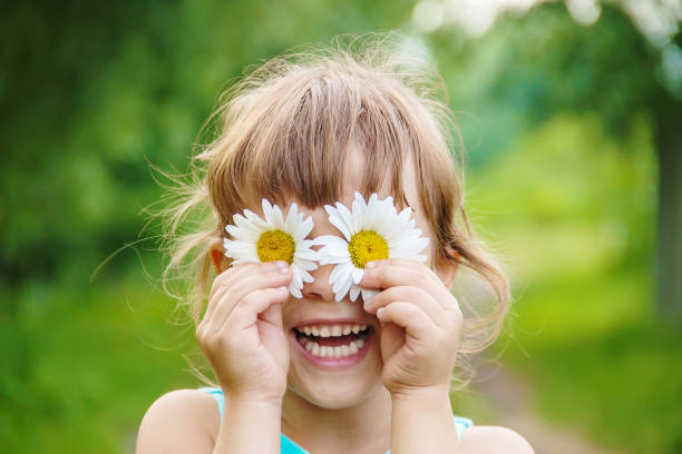 カモミールの花、彼女の手で少女を保持しています。選択と集中。 - huge eyes ストックフォトと画像