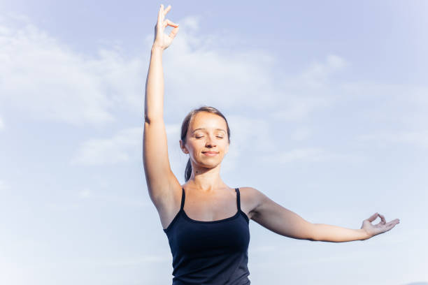istock Young attractive smiling woman practicing yoga on a lake 1035964546