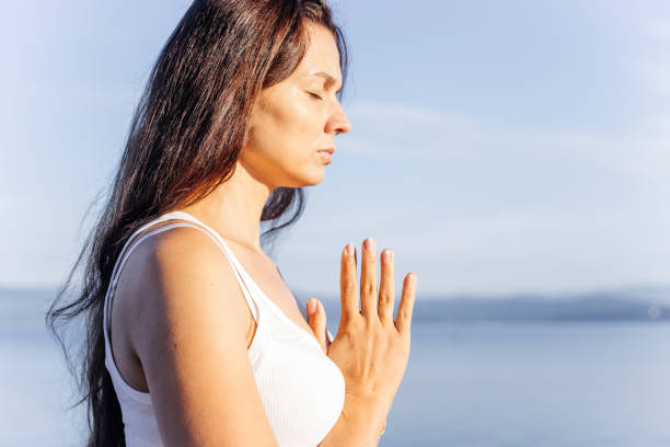istock Young attractive smiling woman practicing yoga on a lake 1035966834