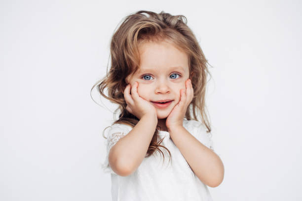 niña linda en vestido blanco sonriendo a cámara - little girls small blond hair child fotografías e imágenes de stock