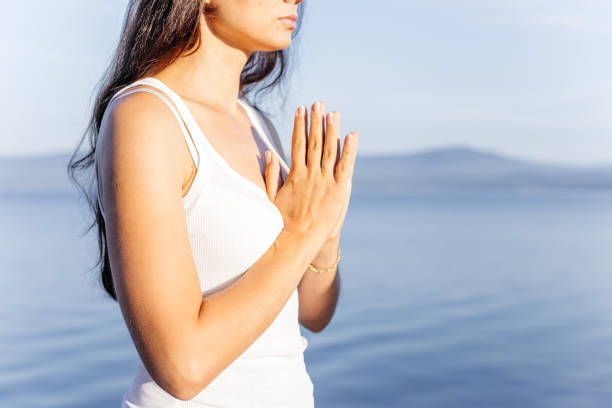 istock Young attractive smiling woman practicing yoga on a lake 1035971536