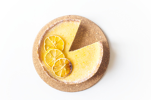 Lemon tart with dried lemons as a decoration from above on a white background. Home baking autumn concept. Top view, flat lay, minimal