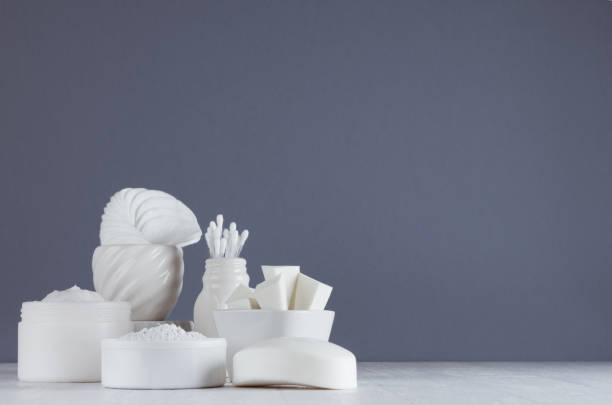 istock White cosmetics products set in different white bowls on wood table and grey wall with copy space. 1035975154
