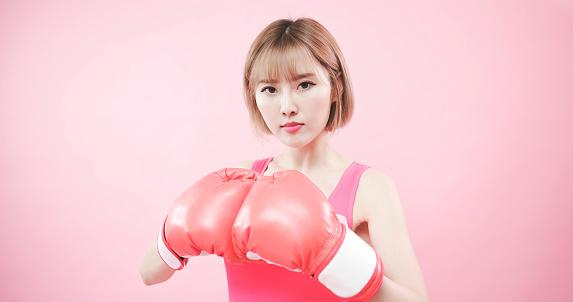 woman wear pink ribbon and hold boxing gloves with prevention breast cancer concept