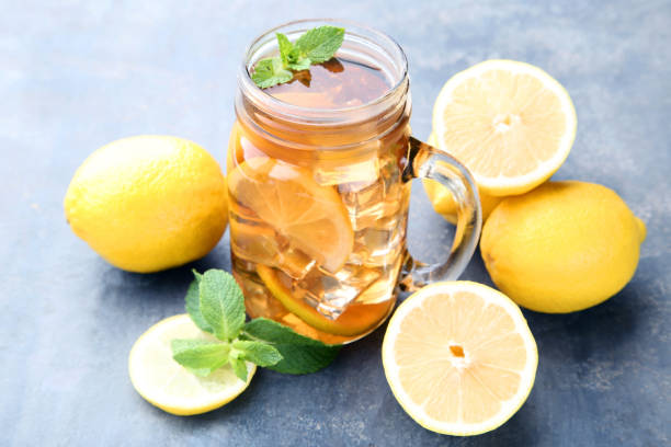 istock Ice tea in glass jar with lemon and mint leafs on wooden table 1035978810