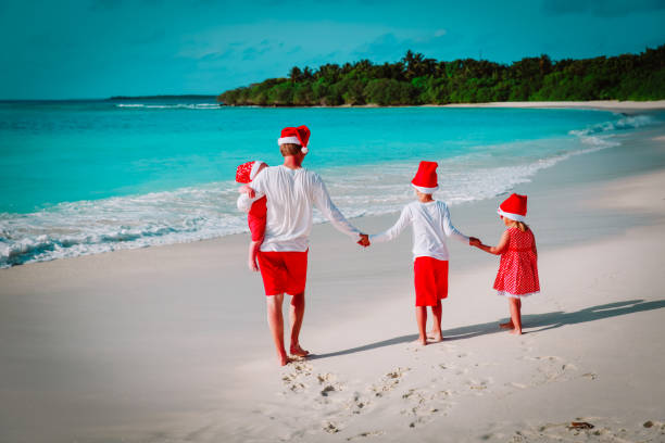 istock father with kids walk on tropical beach at Christmas 1035981394