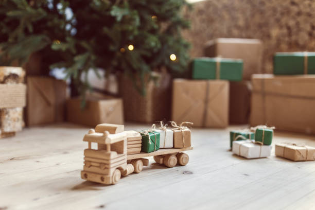 istock Wooden toy car with christmas gift boxes on top. Selective focus on box 1035984766