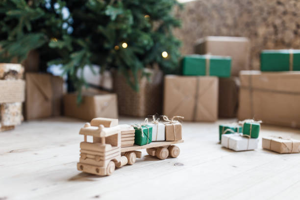 istock Wooden toy car with christmas gift boxes on top. Selective focus on box 1035984810
