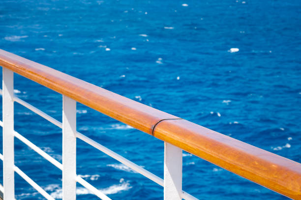 Cruising, relaxation at sea and maritime travel by cruise ship concept with a peaceful scene of a handrail with nobody around it, overlooking the tranquil ocean on a warm summer day with copy space