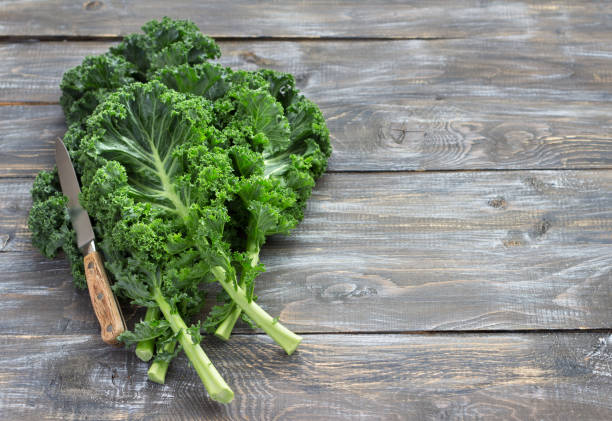 istock Fresh green curly kale leaves on a wooden table 1035987566