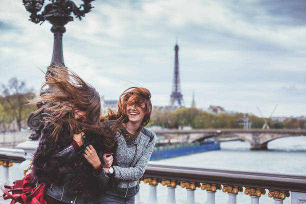 amis heureux à paris avec des poils ébouriffés journée venteuse - cheveux dans le vent photos et images de collection