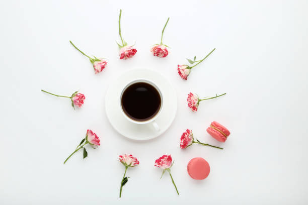 istock Rose flowers with cup of coffee and macaroons on white background 1035995364