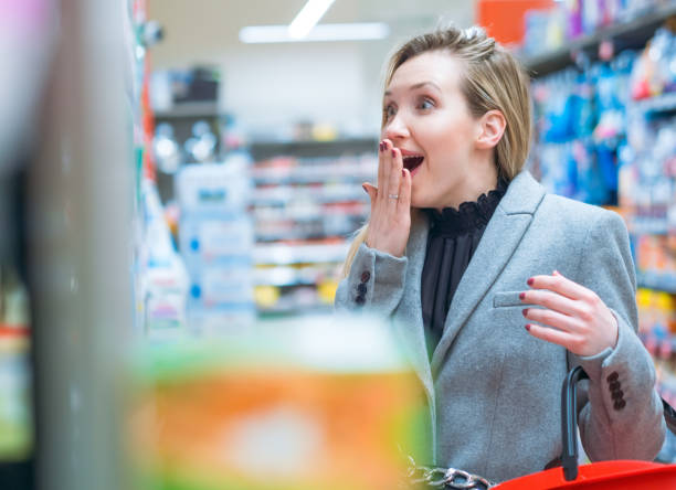 Disbelief. Surprised woman in supermarket stock photo